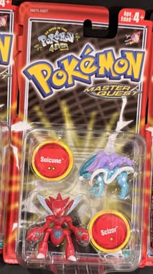 Blister sellado Hasbro: Suicune + Scizor en CHAROLA PLANA cuadrada (la otra versión lleva cada figura en su burbuja). Reverso de la cartela de charola (pieza de Oscar, 23-sep-2026): © 2003, inglés/francés/español, surtido 58970.